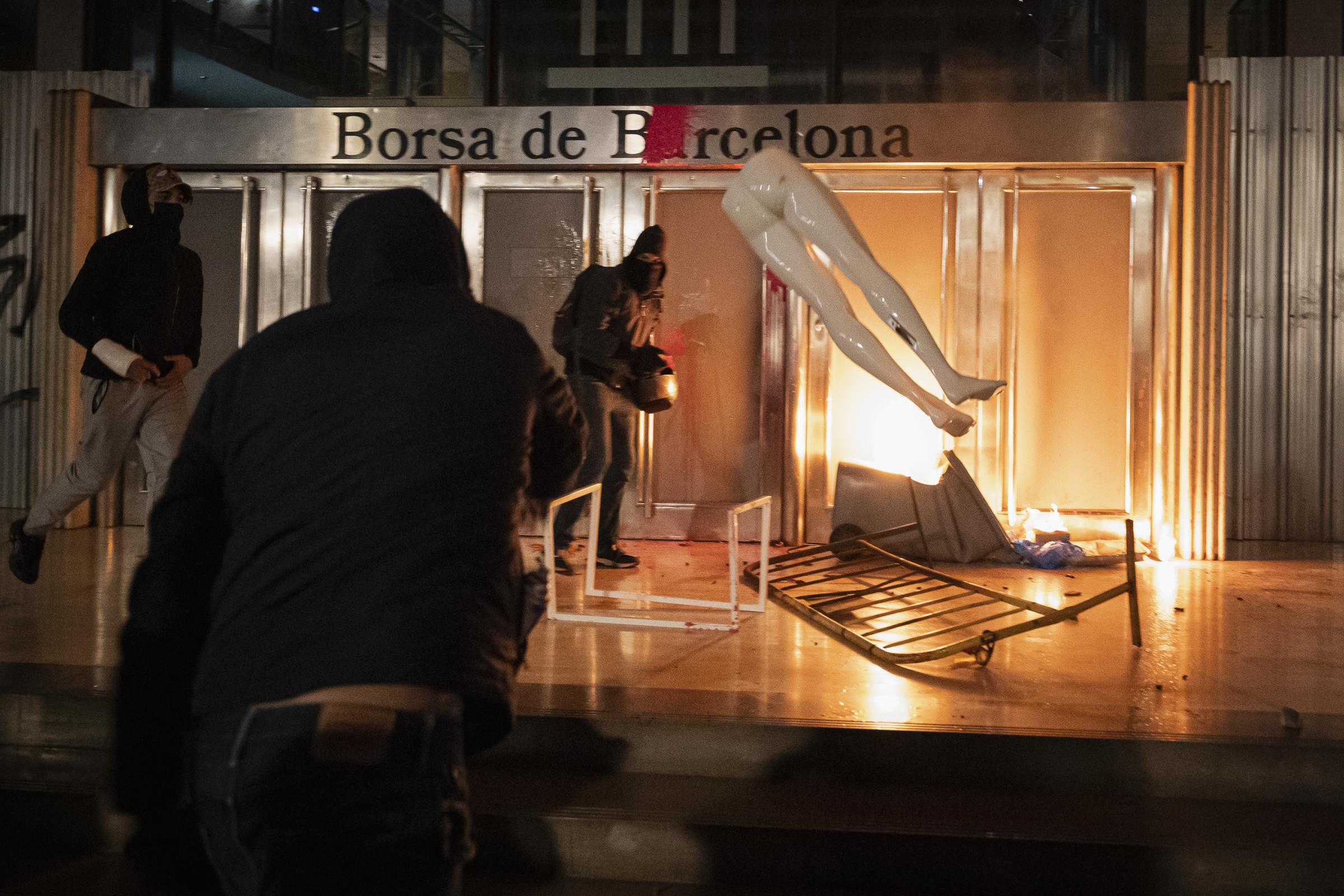 A demonstrator throws part of a mannequin, taken from a looted store in Paseo de Gracia, towards...