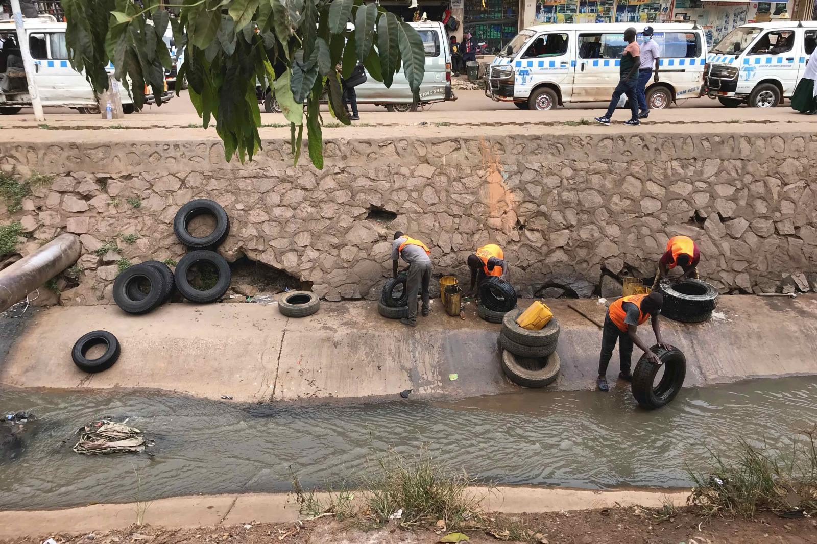  Workers utilize Nakivubo Channel to clean car tires. 