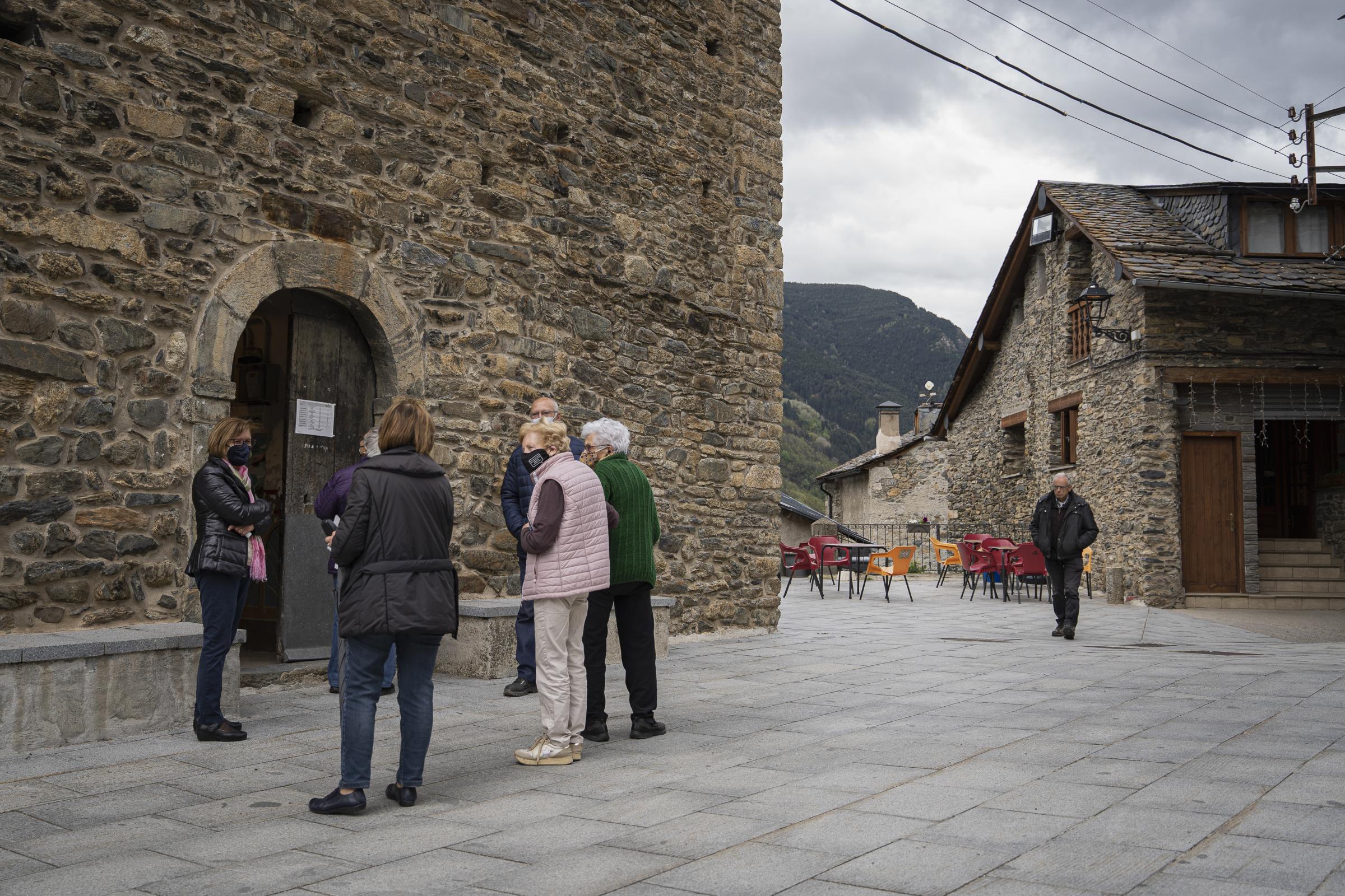  A group of villagers chat outside the Romanesque parish church of Sant Juli&agrave;...