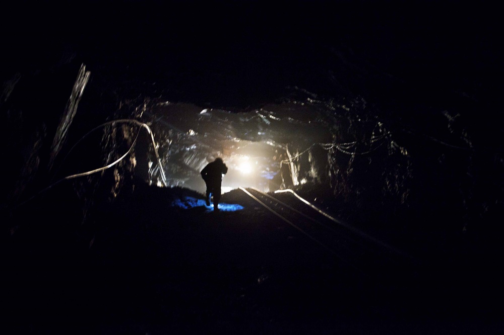 A miner climbs inside a goldmine.