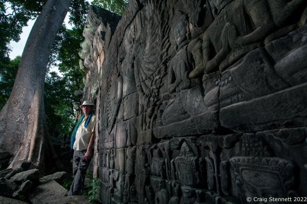 BANTEAY CHHMAR. CAMBODIA-MAY 22: British architect John Sanday (OBE) stands beside a carved image on a temple wall depicting the 'God' Avalokiteshvara at the Khmer temple of Banteay Chhmar, Banteay Meanchey, Cambodia on May 22, 2012. The temple of Banteay Chhmar, meaning 'The Citadel of the Cats' was built by Khmer King Jayavarman 7th (1181-1219) in the 12th Century. According to the UNESCO world heritage centre the temple is a unique complex of the Angkorian period of structural style. However, the temple complex through the effects of time and the elements is slowly crumbling back into the jungle. Teams of Cambodian archeologists, stone masons and with assistance from the Global Heritage Fund and Cambodian government are mounting a rescue mission in order to stem the temple's continued collapse.(Photo by Craig Stennett/Getty Images)