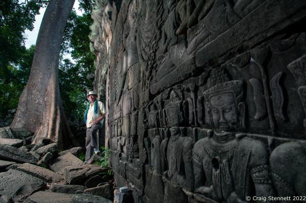BANTEAY CHHMAR. CAMBODIA-MAY 22: British architect John Sanday (OBE) stands beside a carved image on a temple wall depicting the 'God' Avalokiteshvara at the Khmer temple of Banteay Chhmar, Banteay Meanchey, Cambodia on May 22, 2012. The temple of Banteay Chhmar, meaning 'The Citadel of the Cats' was built by Khmer King Jayavarman 7th (1181-1219) in the 12th Century.According to the UNESCO world heritage centre the temple is a unique complex of the Angkorian period of structural style. However, the temple complex through the effects of time and the elements is slowly crumbling back into the jungle. Teams of Cambodian archeologists, stone masons and with assistance from the Global Heritage Fund and Cambodian government are mounting a rescue mission in order to stem the temple's continued collapse.(Photo by Craig Stennett/Getty Images)