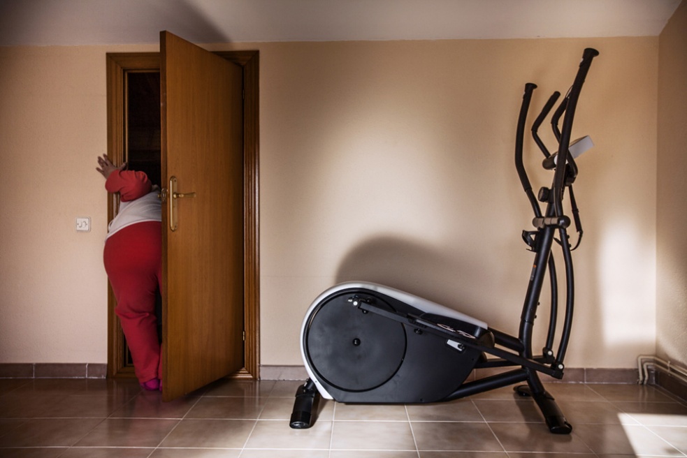 Sandra in the attic of her hous...exercise machines, seldom used.