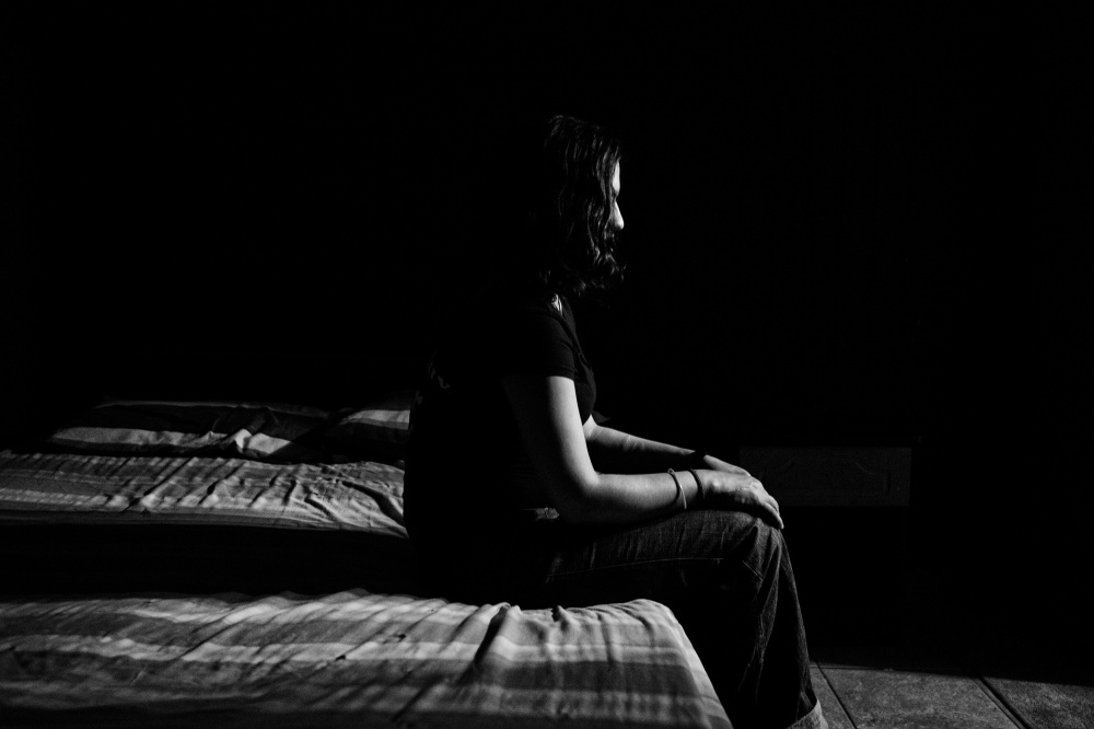Evaggelia, a drug addict and prostitute, sits at a hotel bed in central Athens. Evaggelia prostitutes daily for 5 to 10 euros.