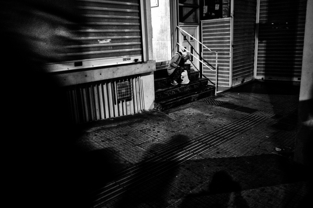 Little Left to Lose - A drug-addict sits at the entrance of a building in...