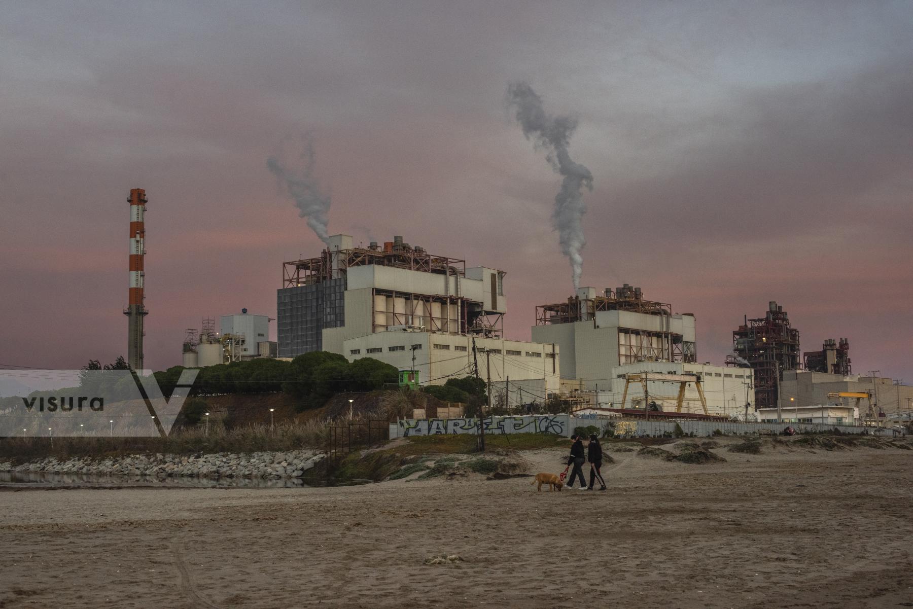 Purchase A couple walks with their dog in the bay of Ventanas near the AES Geners thermoelectric plant by cristobal Venegas